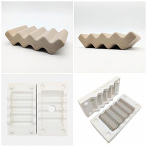 May include: A beige ceramic soap dish with a wavy design. The dish has a series of ridges, creating a textured surface. The soap dish is shown from multiple angles, including the mold used to create it.