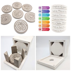 May include: Set of seven chakra coasters with a mold for making more. The coasters are made of concrete and feature the symbols for each chakra. The mold is made of white plastic and has a removable top. The mold is labeled "Chakra Holder".