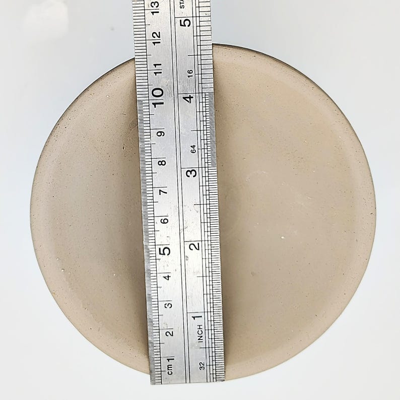 May include: A beige ceramic bowl with a diameter of 5 inches. The bowl is shown next to a ruler for size reference.