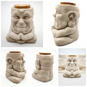 May include: A ceramic figurine of a smiling Buddha sitting in a meditative pose with hands clasped in front. The figurine has a cork top and is a light beige color.