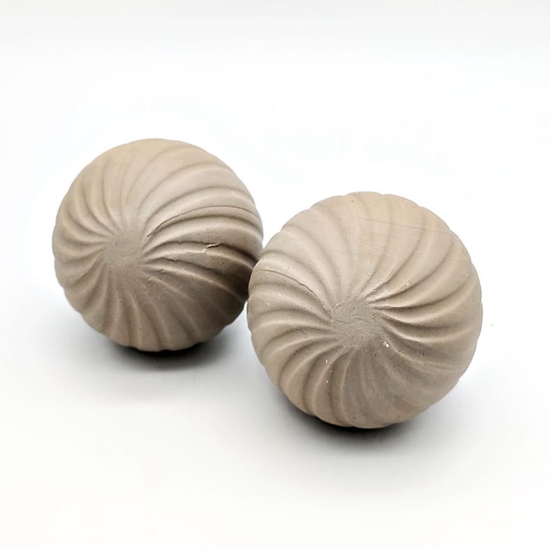 May include: Two decorative spheres made of a light brown material with a swirl pattern.