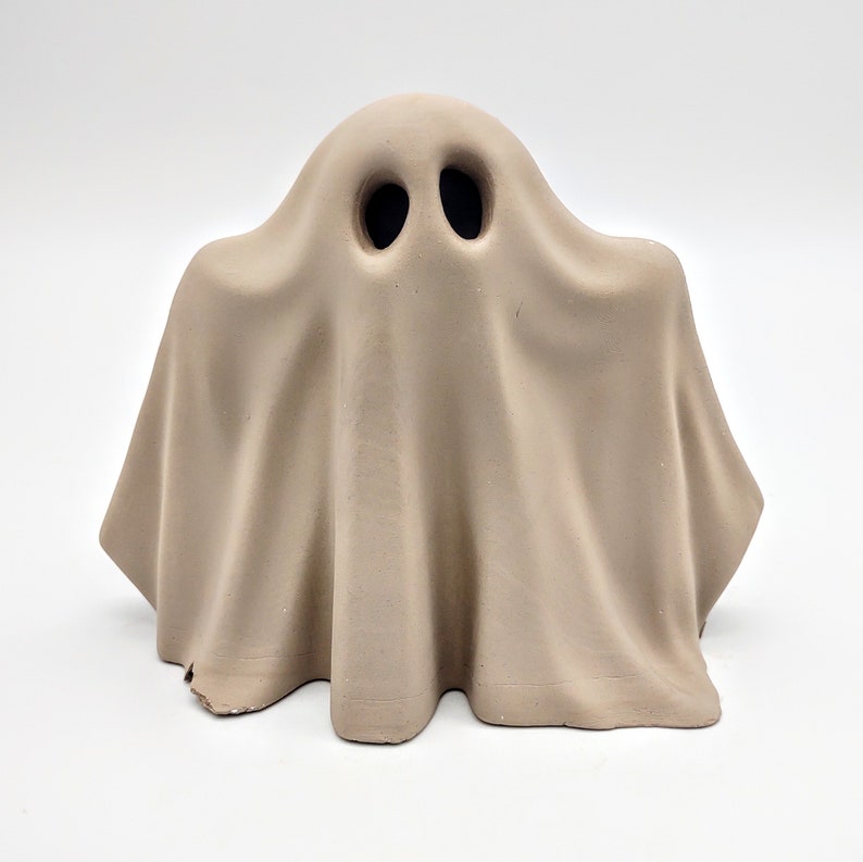 May include: A beige ceramic ghost figurine with two black eye holes.
