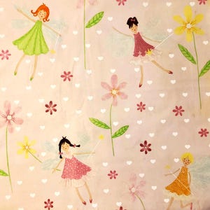 May include: A pale pink fabric design with a repeating pattern of fairies, flowers, and hearts. The fairies are shown with colourful dresses, wings, and wands. Flowers are in shades of pink and yellow, with green stems and leaves. White hearts are scattered across the background.