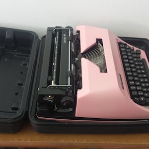 Manual portable typewriter with carrying case, pink color, Works well, with telephone, set of two (02) pieces available colors,