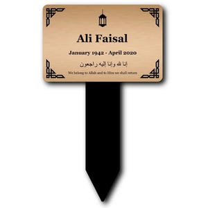 Könnte beinhalten: Rechteckige Gedenktafel mit hellbrauner Holzoptik. Sie trägt den Namen "Ali Faisal" und die Daten "Januar 1942 - April 2020". Enthält arabische Schrift und den englischen Satz "We belong to Allah and to Him we shall return".
