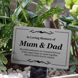May include: A silver metal memorial plaque with black text that reads "In Loving Memory of Mum & Dad. Beautiful memories are treasured forever of the happy times we spent together. Always loved & forever missed."