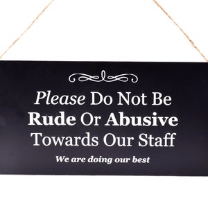 Peut inclure: Une pancarte noire avec du texte blanc qui dit "Veuillez ne pas être impoli ou abusif envers notre personnel. Nous faisons de notre mieux."