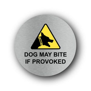Puede incluir: Un letrero redondo de metal cepillado con el texto "DOG MAY BITE IF PROVOKED". El letrero presenta un triángulo amarillo con una silueta negra de un perro gruñendo.