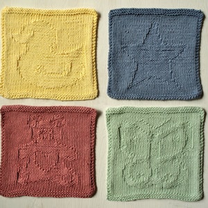 May include: Four knitted washcloths in yellow, blue, red, and green. Each cloth features a different design: a duck, a star, a castle, and a butterfly. The cloths are square and have a textured appearance.