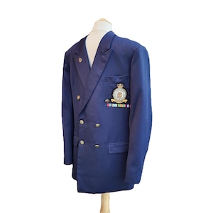 May include: A navy blue double-breasted blazer with gold buttons and a badge on the pocket. The badge features a crown and the words "Royal Air Force".