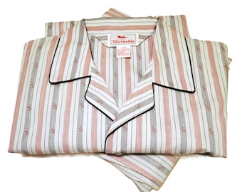 Puede incluir: Conjunto de pijama vintage con un estampado de rayas rojas, negras y blancas. La parte superior tiene un cuello con ribete negro y la etiqueta de la marca "Warrendale". El pijama está doblado cuidadosamente.