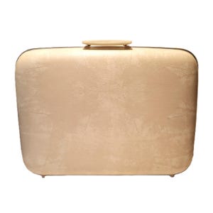 May include: A rectangular, beige clutch with a rounded top and bottom. The clutch has a textured surface and a small, light-colored handle on top. The clutch is a neutral color and appears to be made of a leather-like material.