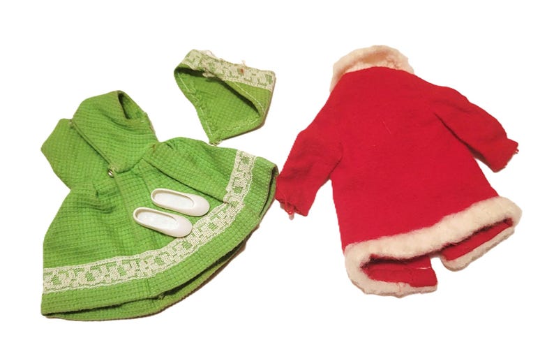 May include: A collection of doll clothes, including a green dress with a matching bonnet and white shoes, and a red coat with white trim. The dress has a textured pattern and lace trim.
