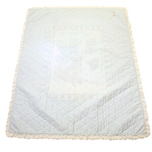 May include: A light blue quilted blanket with a white lace trim. The blanket is made of a soft, comfortable fabric and is perfect for snuggling up on the couch.