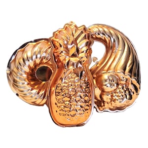 May include: Three vintage copper-colored metal molds. The molds are in the shapes of a pineapple, a bundt cake, and a cornucopia. The pineapple mold is in the center, with the bundt cake mold on the left and the cornucopia mold on the right.