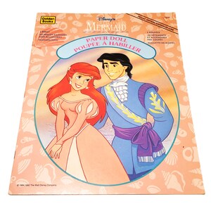 May include: A vintage Disney's The Little Mermaid paper doll set. The cover features Ariel and Prince Eric in a circular frame. The cover text includes "Paper Doll" and "Poup&eacute;e &agrave; Habiller". The set includes dolls, precut fashions, and accessories.
