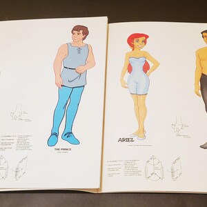May include: Open book featuring illustrations of Disney characters Snow White, The Prince, Ariel, and Eric. Each character is depicted in a unique outfit with accompanying text labels.