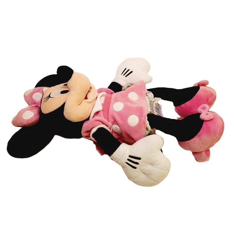 May include: A pink and black plush toy of Minnie Mouse with white polka dots on her dress. She is lying on her side with her head turned to the side.