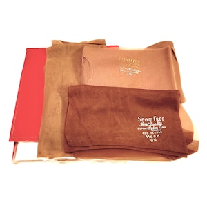 May include: A stack of brown and beige nylon stockings with labels that read "Golneaton Crepe" and "Seam Free Best Quality Du Pont Nylon Yarn 400 Needle Mesh 8 1/2".