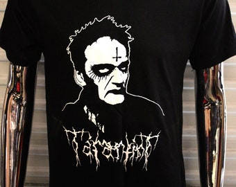 May include: Black t-shirt with a white graphic of a man's face with a cross on his forehead and the text "Mayhem" in a black metal font.