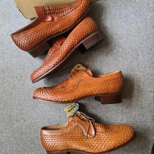 May include: Three pairs of brown leather woven shoes with a low heel. The shoes have a lace-up design and a woven leather upper. The shoes are in a new condition and are displayed on a grey surface.
