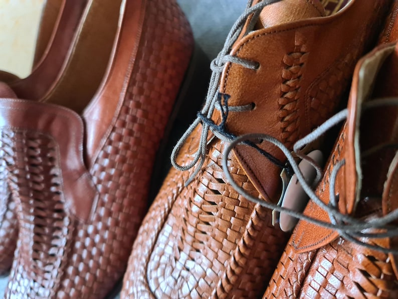 May include: Two pairs of brown leather woven shoes with laces. The shoes have a woven pattern and are made of a soft, supple leather.