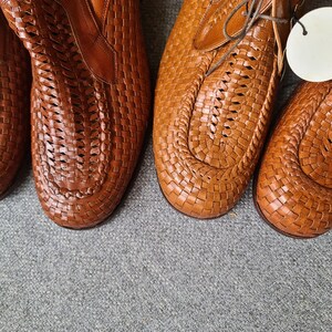 May include: Two pairs of brown leather woven shoes with a lace-up design.