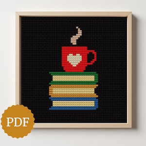 May include: Cross-stitch art of a red mug with a white heart, steam rising, atop a stack of books. The books are green, gold, and blue. The background is black, and the artwork is in a wooden frame. A PDF logo is in the lower left corner.