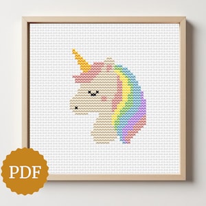 May include: Cross-stitch design of a unicorn's head in a wooden frame. The unicorn has a yellow horn, pink mane, and a rainbow mane. The PDF logo is in the bottom left corner.