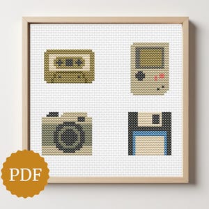 May include: Cross-stitch artwork in a wooden frame featuring four retro icons: a cassette tape, a handheld game console, a camera, and a floppy disk. The artwork is on a white background. A PDF icon is in the lower left corner.