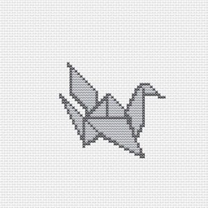 Op de afbeelding: Een kruissteekpatroon met een gestileerde origami-kraanvogel in grijstinten. Het ontwerp bestaat uit individuele X-vormige steken op een witte rasterstof, wat een geometrische vogelvorm cre&euml;ert met puntige vleugels en een staart.