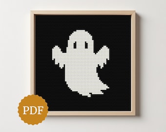 Puede incluir: Patrón de punto de cruz enmarcado con un fantasma blanco sobre fondo negro. El fantasma tiene un diseño simple y pixelado. El marco es de color marrón claro. Un logotipo PDF está en la esquina inferior izquierda. Ideal para Halloween.