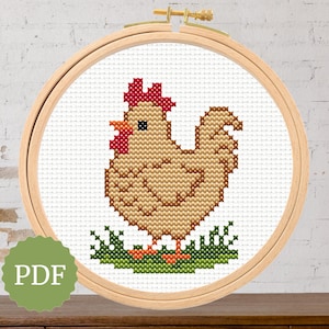 May include: A cross-stitch design of a hen in a wooden embroidery hoop. The hen is light brown with a red comb and wattle, standing on green grass. The word "PDF" is in a green circle.