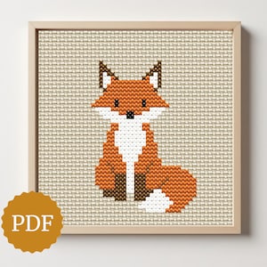 May include: A framed cross-stitch of a fox. The fox is orange, white, and brown, with a detailed design. The background is a neutral beige color. A gold-colored PDF logo is in the lower left corner. The frame is light brown.