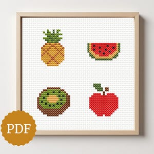 May include: A framed cross-stitch pattern featuring a pineapple, watermelon slice, kiwi, and apple. The fruits are rendered in vibrant colors against a white background. The frame is light wood, and a PDF icon is in the lower left corner.
