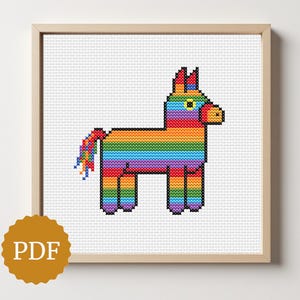 May include: A framed cross-stitch pattern of a colorful piñata. The piñata is designed with a rainbow of colors, including red, orange, yellow, green, blue, and purple. The image is in a wooden frame and includes a PDF icon.