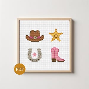 Könnte beinhalten: Ein gerahmtes Kreuzstichmuster mit vier Western-Motiven: ein brauner Cowboyhut mit rosa Band, ein gelber Sheriffstern, ein graues Hufeisen mit einem rosa Stern in der Mitte und ein rosa Cowboystiefel mit braunem Absatz auf weißem Stoff.