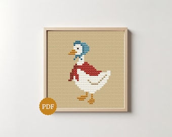Op de afbeelding: Een kruissteekpatroon met een witte gans die een blauwe muts en een rode sjaal draagt. De gans heeft een oranje snavel en oranje poten op een beige Aida-stof. Een ronde gouden badge met de tekst PDF bevindt zich in de hoek.