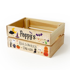 May include: A light-coloured wooden crate featuring Halloween-themed graphics and the text "Poppy's HALLOWEEN TREATS". The illustrations include a yellow moon, purple witch hat, bats, a ghost, a tombstone, pumpkins, a black cat, and a skull.
