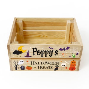 May include: A rectangular light-coloured wooden crate featuring Halloween-themed graphics and the text "Poppy's HALLOWEEN TREATS". The design includes a yellow crescent moon, purple witch hat, bats, spider web, ghost, tombstone, pumpkins, and a black cat.