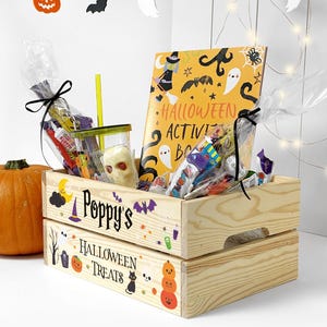 May include: A light-coloured wooden crate featuring the text Poppy's Halloween Treats and colourful holiday graphics. Inside are clear plastic bags filled with assorted sweets, a skull-shaped item, and a Halloween activity book.