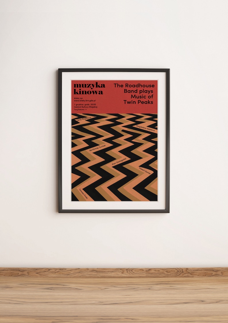 May include: A black framed poster with a red background and black and brown zig-zag pattern. The poster advertises a music event called "muzyka kinowa" featuring the Roadhouse Band playing music from the TV show Twin Peaks.