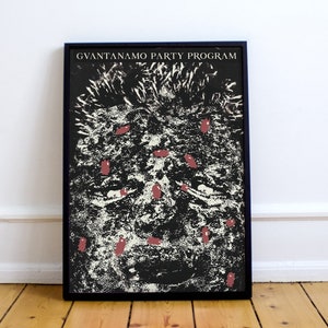 May include: A black and white poster with the text "GUANTANAMO PARTY PROGRAM" at the top. The poster features a close-up of a person's face with red splotches on the skin.