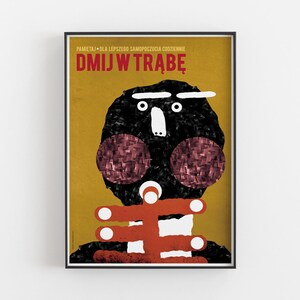 May include: A yellow poster with black text that reads "PAMIĘTAJ - DLA LEPSZEGO SAMOPOCZUCIA CODZIENNIE DMIJ W TRĄBĘ". The poster features a black and white illustration of a person with red cheeks and a red and white striped collar.