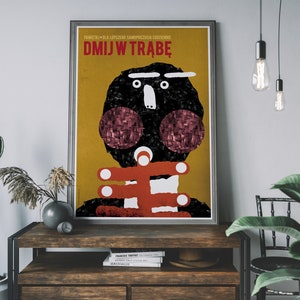 May include: A yellow and red poster with a black and white illustration of a person's face. The poster has the text "DMJW TRABĘ" in red letters.