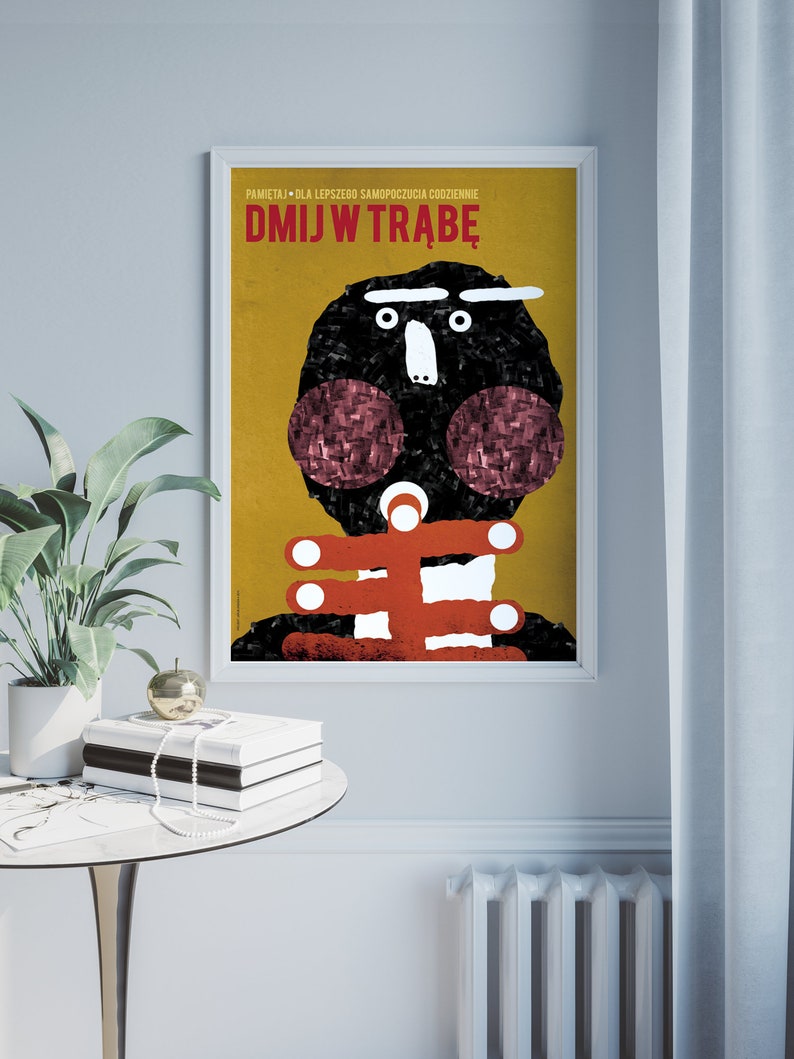 May include: A yellow and black poster with the text "DMJW TRABE" in red. The poster features a cartoon illustration of a person with a black head and red cheeks.