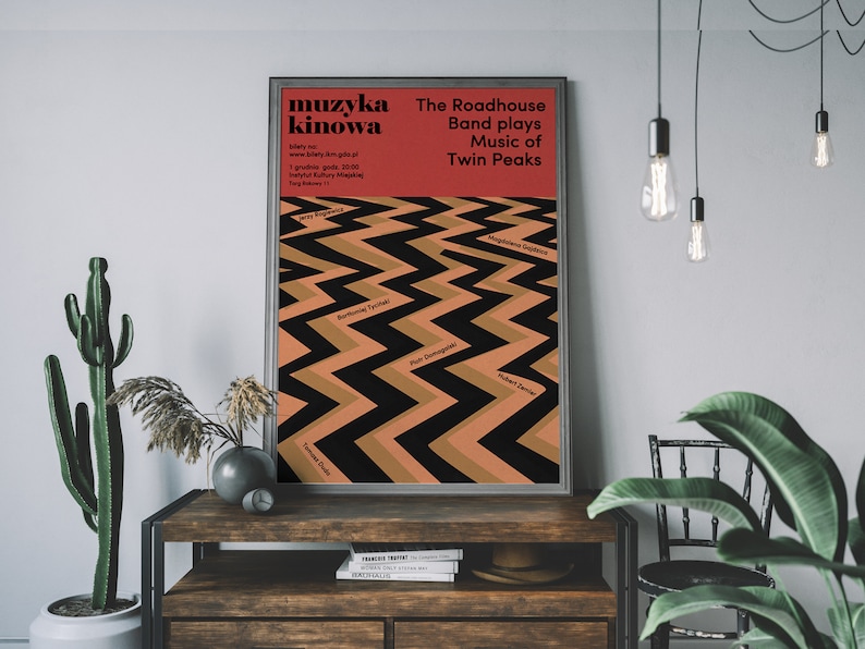 May include: A red and black poster with the text "muzyka kinowa" and "The Roadhouse Band plays Music of Twin Peaks". The poster features a black and brown zig-zag pattern with the names of the show's characters.