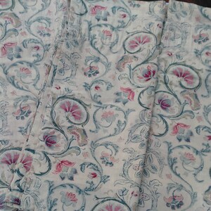 May include: Three white fabric panels with a repeating pattern of blue and pink floral designs. The fabric has a slightly textured surface.