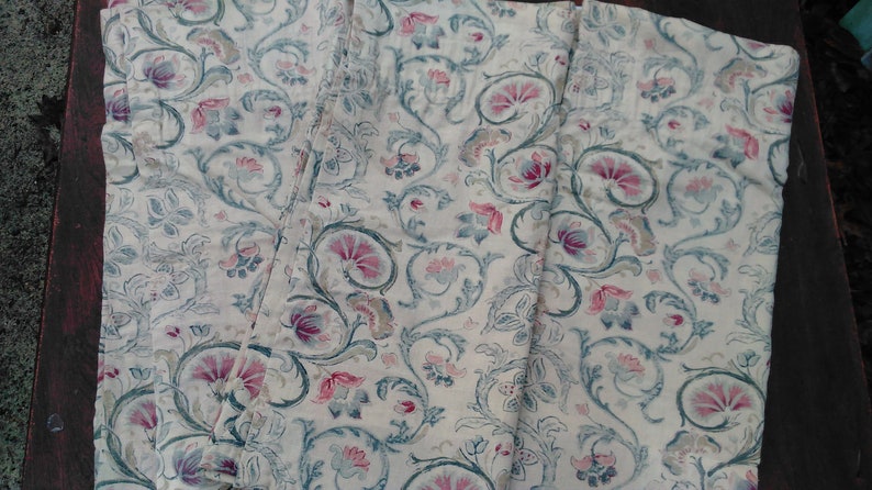 May include: Three white fabric panels with a repeating pattern of blue and pink floral designs. The fabric has a slightly textured surface.