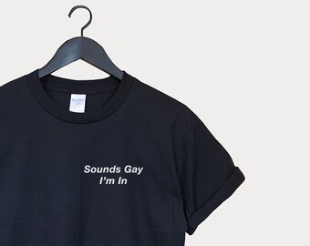 May include: Black t-shirt with white text that reads "Sounds Gay I'm In".